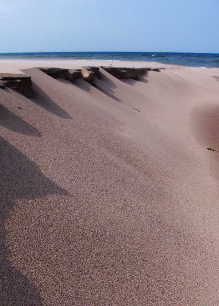 Winds of time and warm temperatures erase the sand sculptures shown above along Pier Cove Creek banks.