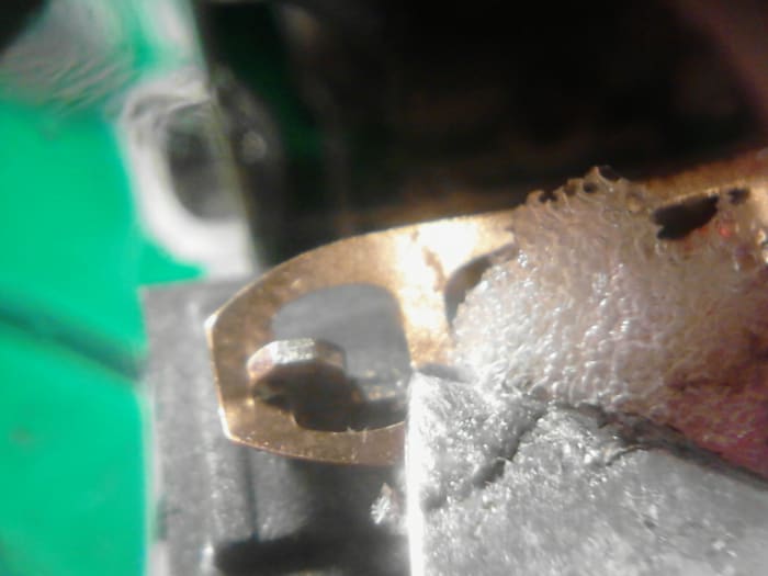 Using a knife or small pointed object, press down gently on the small strip of metal going across the metal switch tab. This is the contact point of the switch when it is pressed down.