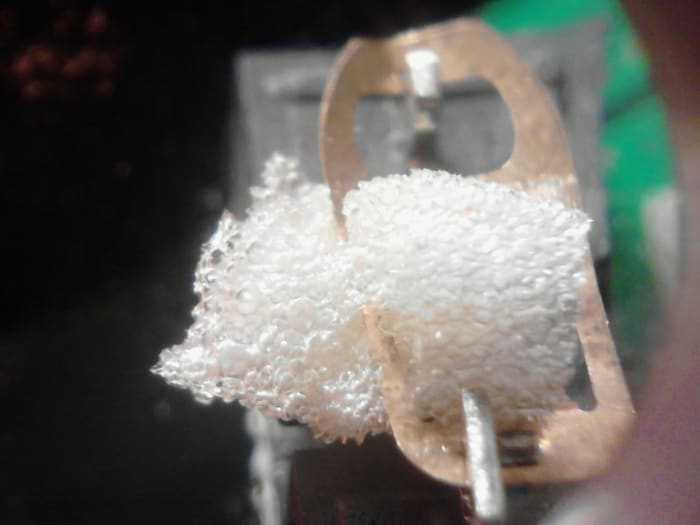 Top view of the same piece of foam on the switch showing it pulled about half way through the metal contact tab.