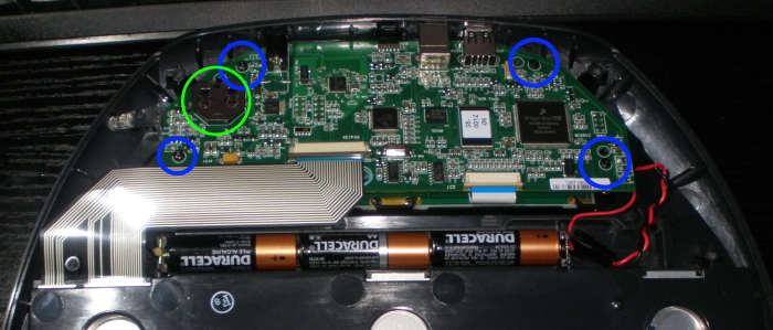 Remove another four T6 screws circled in blue, from the motherboard. The battery holder is circled in green.
