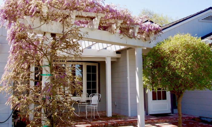 Here is the cropped and edited version. Colors are enhanced a bit and the shadowed portion is a little lighter, so you can see the patio. The vines, bay window, and patio are features I like in a house, which is why I'd include the photo.