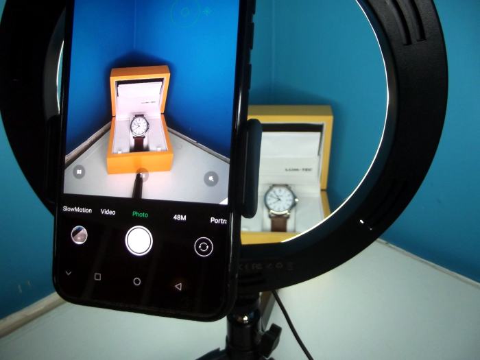 Phone camera is held behind and within the center of the ring light, providing a good view and plenty of unobstructed light