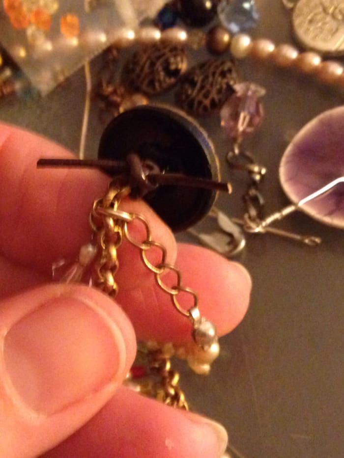 Here the vintage button is secured on a scrap of brown 1 mm round leather cord. Use knotting and a bit of clear nail polish to secure the knot in place.