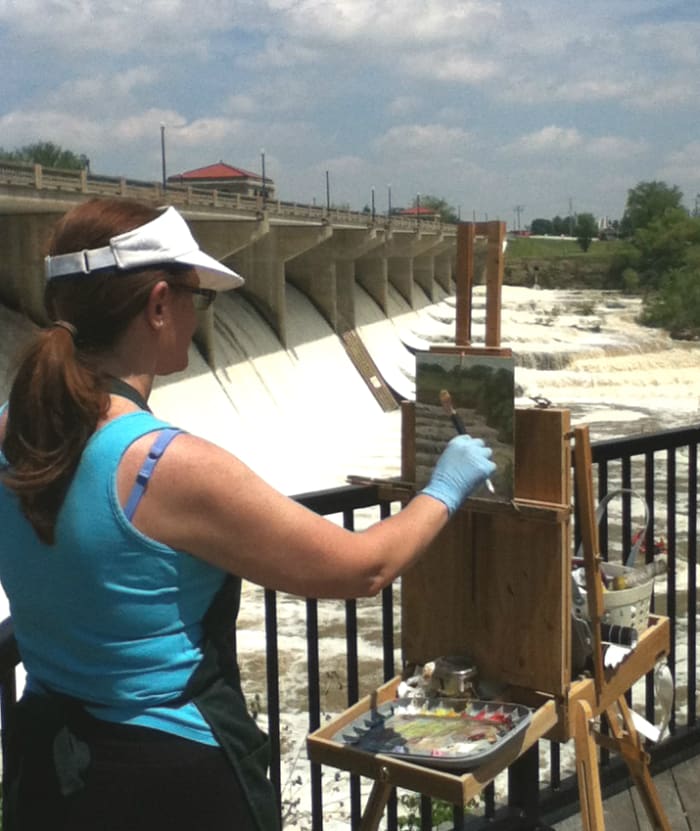 Robie Benve painting outdoors on a very sunny and hot day. Sunscreen and visor are must-haves on a day like that.