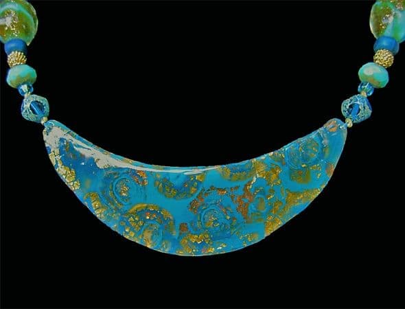 Close-up view of polymer clay mokume gane veneer on metal necklace centerpiece