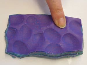 Creating depressions or valleys between the holes to further distort the mokume gane stack