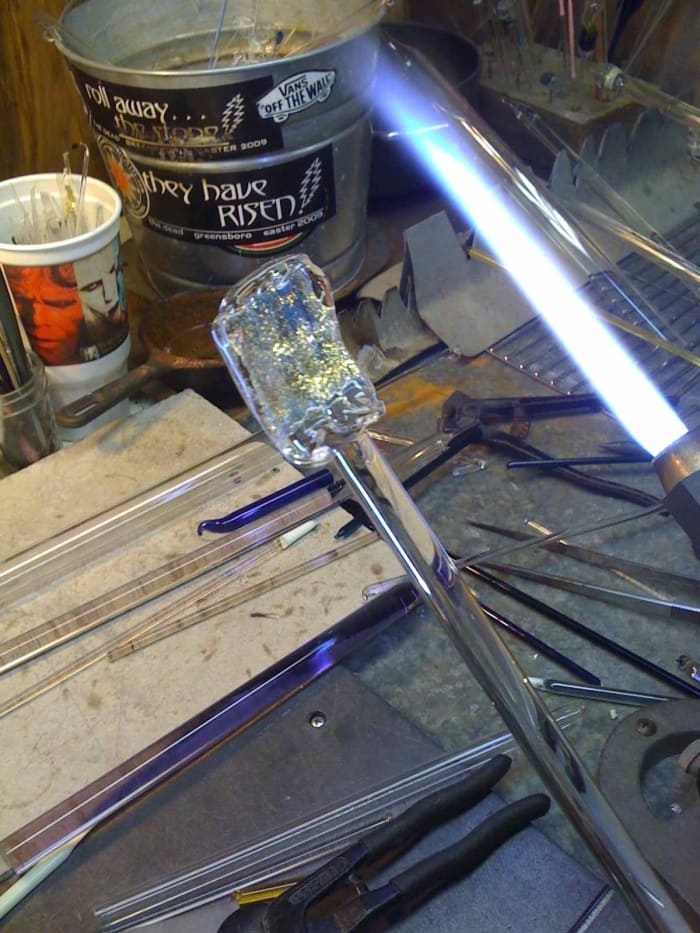 A two inch chip of Dichroic glass coated in a layer of clear glass. This will become the core of a new marble.