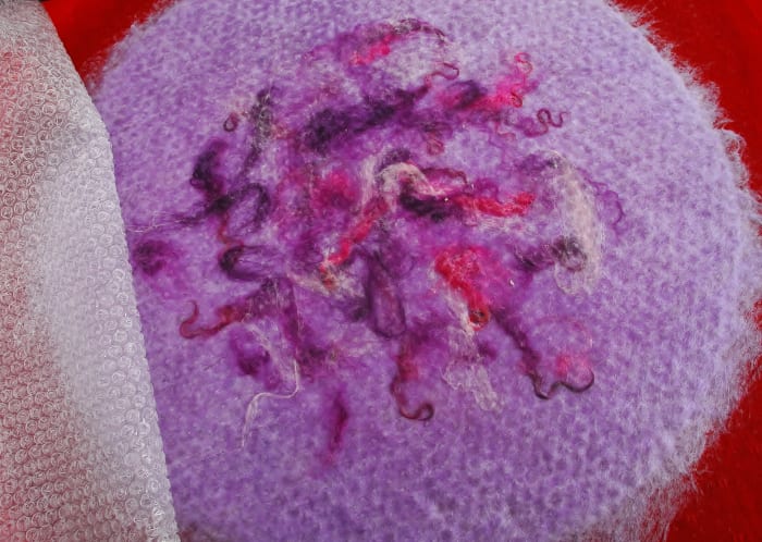 Carefully remove net and replace with bubble wrap again, smooth side up. Continue rubbing until you reach 'pinch test' stage.