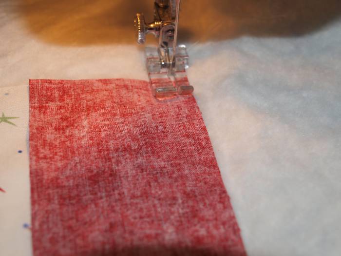 Sew fabric on, going through all layers. Begin sewing a couple of stitches before the fabric strip starts and end a couple of stitches after the fabric strip ends.
