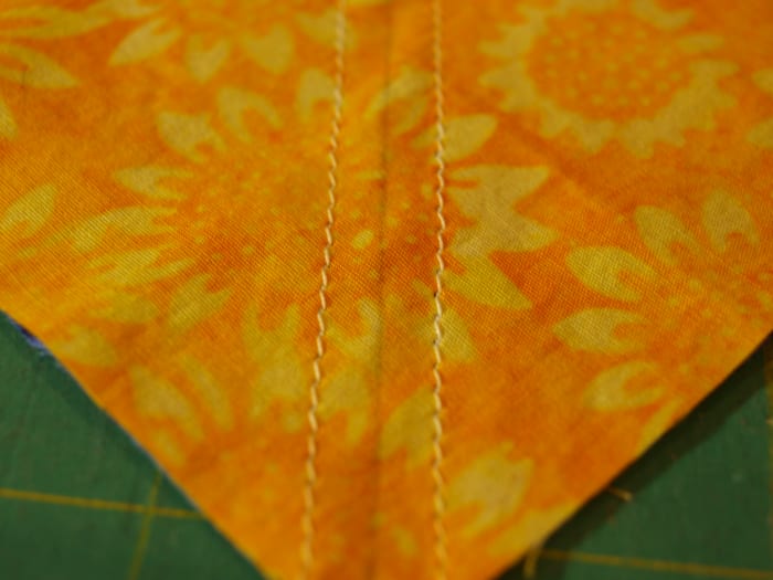 Form the half square triangles. Note the drawn diagonal line and the seams sewn on each side of it.
