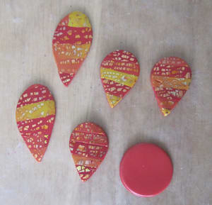Cut out the polymer clay flower petals with a teardrop shaped clay cutter and elongate the petals, if desired.