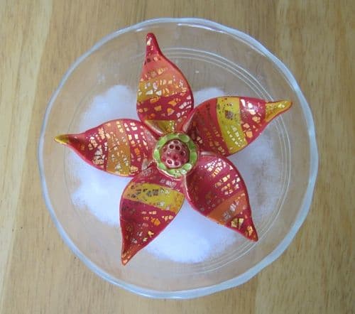 Bake the flower in an oven-safe Pyrex custard cup on top of polyester fiberfill batting. This supports the curved petals as they cure.