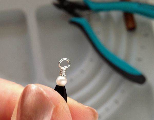 The wire wrapped loop with the trimmed end tucked in and the wrapped section of wire rounded with the crimping pliers