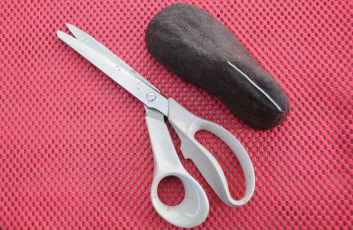 Cut where indicated with a sharp pair of scissors. Gently slip the bootie off the last.