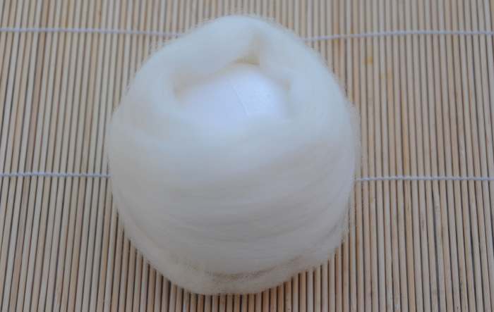 Sides covered with white roving, both ends exposed, waiting to be covered with wool