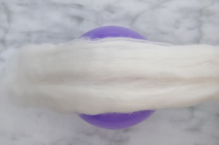 Spread out the roving and wrap the balloon in a piece which goes around with a small overlap.