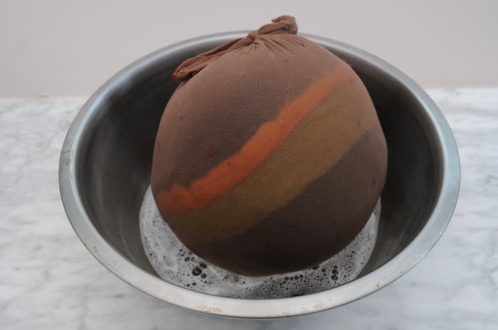 Dunk the ball in hot soapy water, wet and massage the outside of the stocking until the wool has flattened