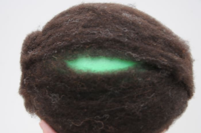 Fill the gaps so that the wool covers the ball evenly, just the gaps, not over the whole area so that the wool becomes uneven in thickness