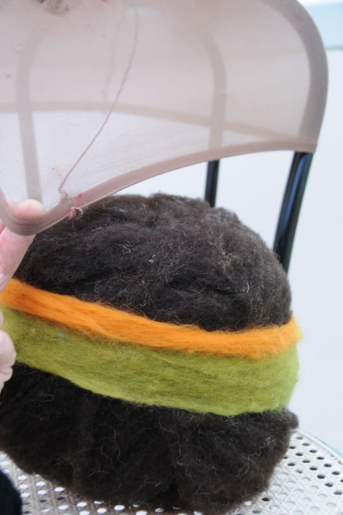 Put the wool covered ball on a chair as shown and lift the ball up into the stocking as shown.