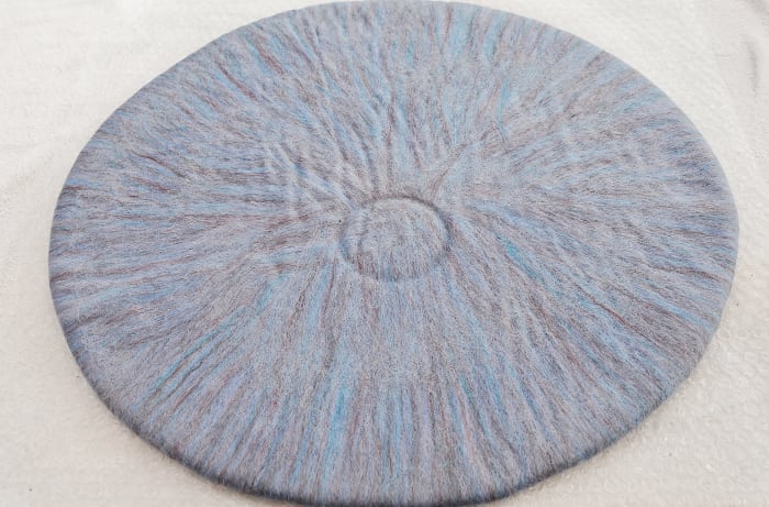 Mark a small circle in the wool with a small round object, about three inches in diameter. I used a roll of masking tape to press the circle with.