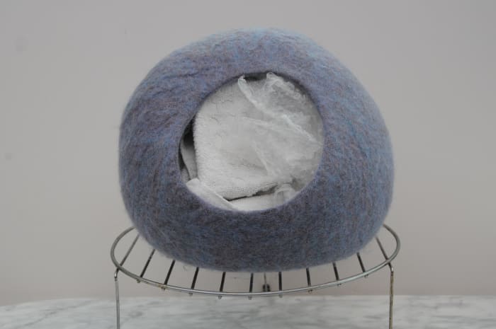 Cat cave stuffed with towels and bubble-wrap, left to shape and dry on a cake rack. Remove the towels and bubble-wrap when it can be seen that the shape will be maintained.