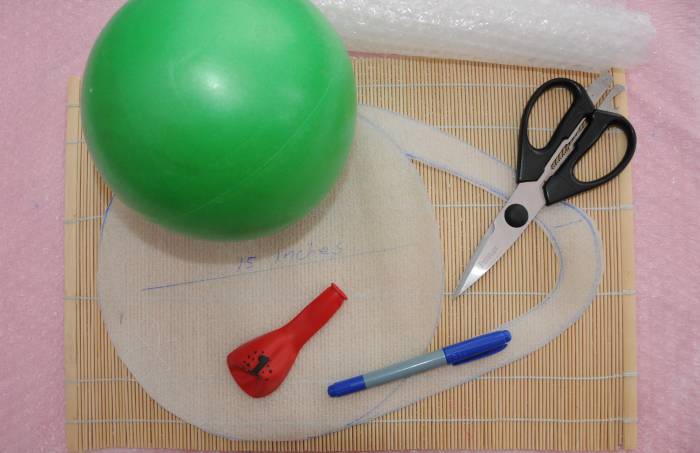 Gertie ball, balloon, scissors, felt tip pen and the template which has been cut out.