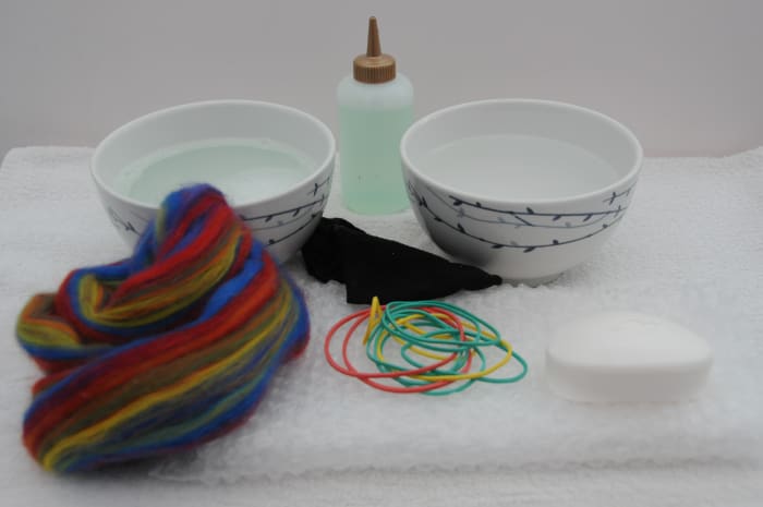 Items required to wet felt a bar of soap, wool roving, hot soapy water elastic bands, piece of bubble-wrap, piece of cut off tights.