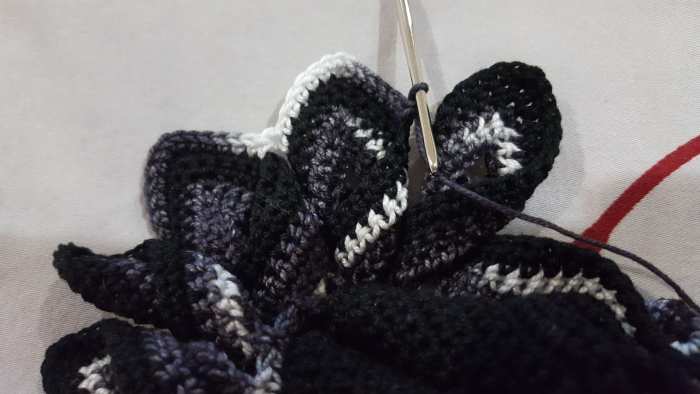 The point on the left of the middle point (where the hook is resting) is the point where the ends are overlapping together. The one to the right of the hook is already twisted and ready for the next set of stitches.