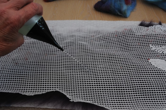 Cover with curtain netting. Wet and smooth down the fibers. Remove the netting and turn the project over.