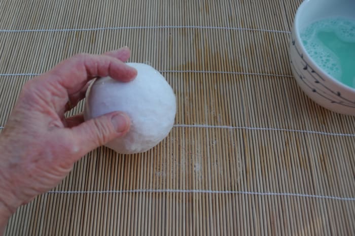 Roll the wool covered ball gently on the bamboo mat to smooth out the woolen Fibres.