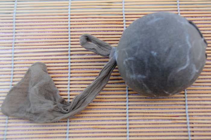 The felt ball inside the foot of a cut off pair of tights. Knot the tights with a slip knot. Put aside until the hat is partially felted..