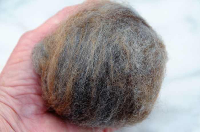 Compress the oddments of wool roving into a tight ball about the size of an open hand.