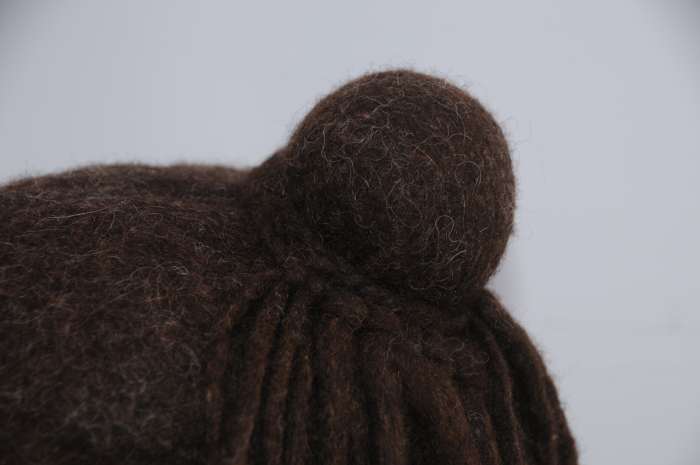 Make a plait using 3 dreadlocks. Attach it loosely to the bun after removing the elastic band and then attach the other half of the dreadlocks to the plait. Tie tightly around the bun.