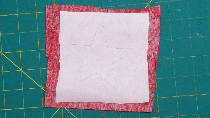 Using your star template, trace the shape onto the paper side of the fusible web that has already been placed on the fabric.
