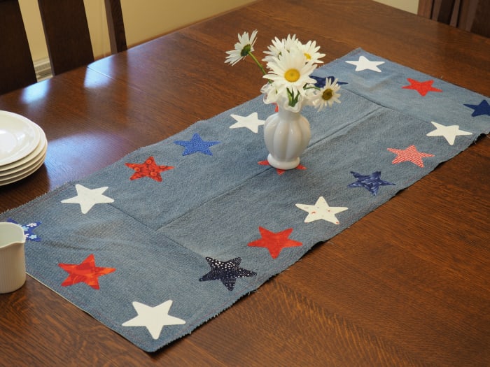 An easy-to-follow tutorial for a DIY patriotic table runner made with repurposed jeans and fabric scraps.