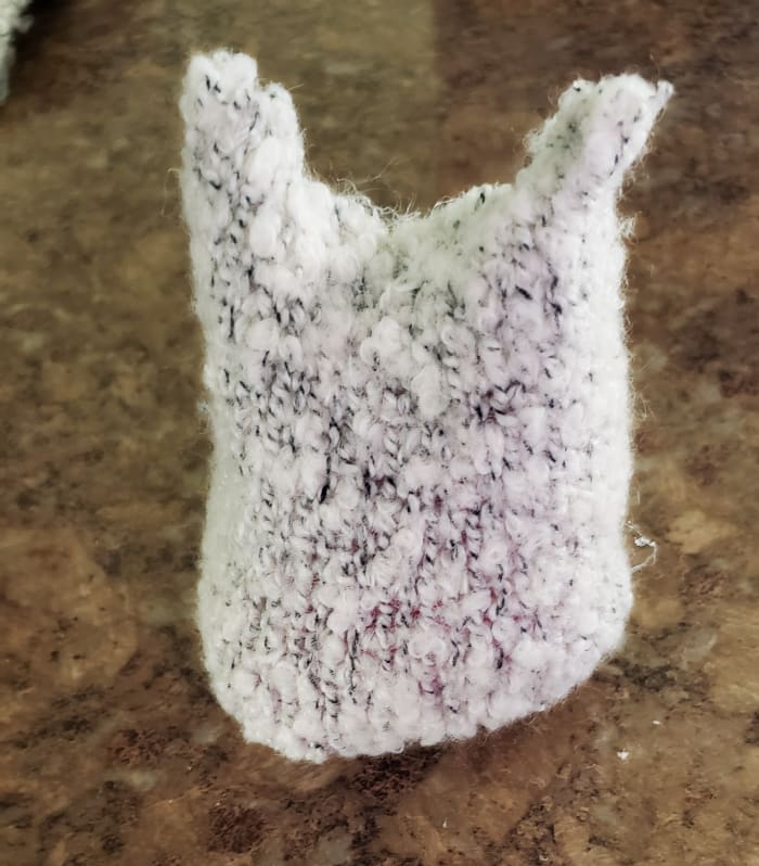 Flip your plushie over and glue buttons on to create eyes. Use a black Sharpie to make a mouth and a pink Sharpie to create cheeks.