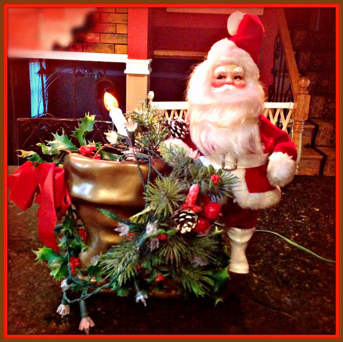Herald Gale Santa's look great in displays. This one is in a golden boot and lights display with lots of holiday holly and greenery for a nice center piece.