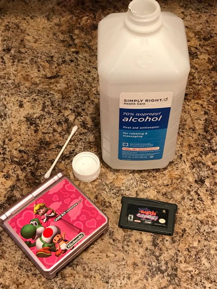 In addition to the game and system, you will also need a cotton swab, rubbing alcohol, and a small container to put the alcohol into.
