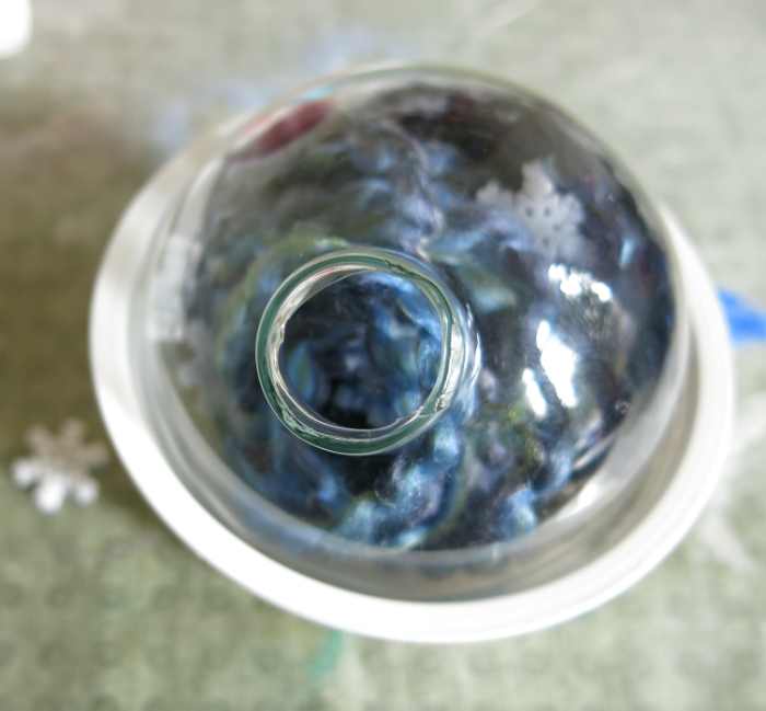 Use a small cup to hold your ornament while working and turn it to drop little items in to accessorize your decoration.