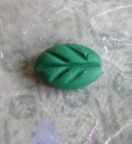 Make leaves by squashing balls of green clay and adding veins with your straight edge.