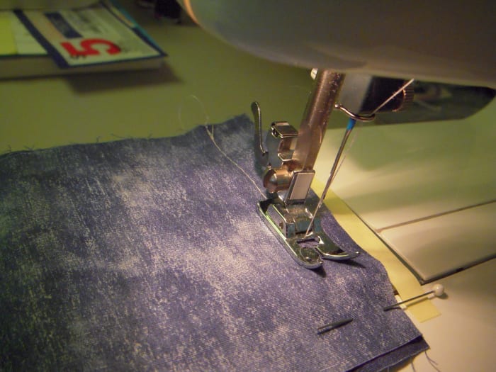 Sew the seam, guide with your left hand, but remember that the feed plate will push your fabric in the right direction (from front to back.)
