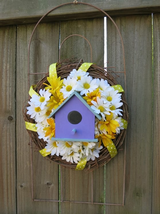 a charming welcome wreath using a garden fence piece, bird house, and some artificial flowers