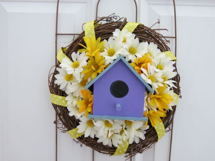 fill in around your bird house with artificial flowers to finish your decorative wreath