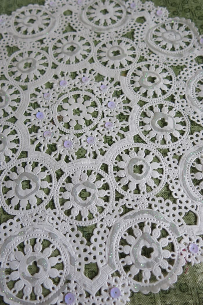 Decorate you paper doily with glitter and sequin to add some sparkle to your paper angel.