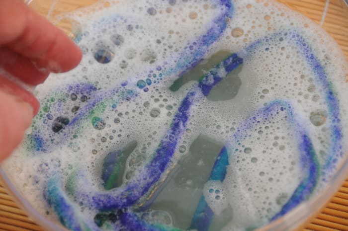 Dunk the length into hot soapy water and roll again. Do this two or three times until the fibers have knitted firmly together.