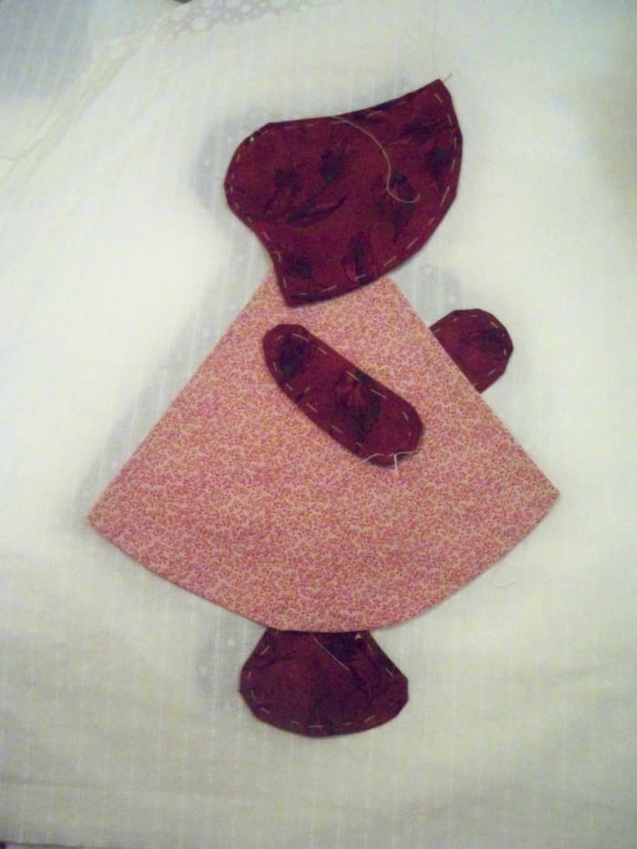 Once she is centered, lift the edges and slide a piece of fusible far enough under so you aren't sewing into it when you do your buttonhole stitches
