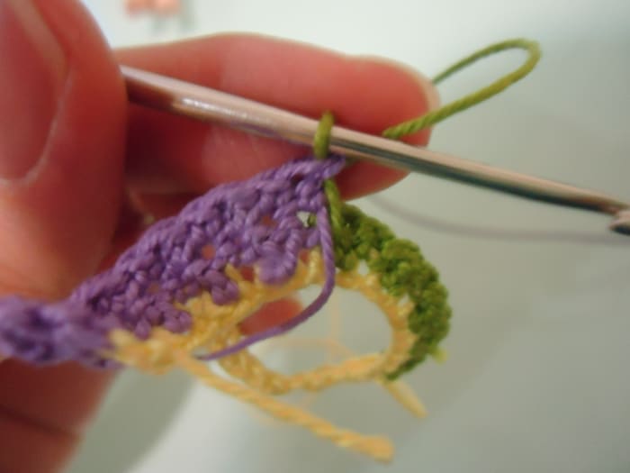 This is how it looks when you change colors in the middle of a row. The previous color is now down while the current color is up and ready to yarn over for the next stitch.