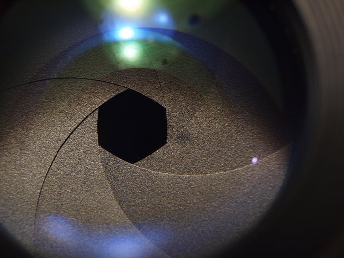 The camera iris is resposible for creating the circular or hexagonal shaped bokeh (depending on the lens).