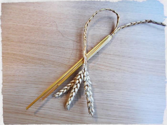 Bend the one plait across the straight stalks to make a half heart, then tie to secure in place.