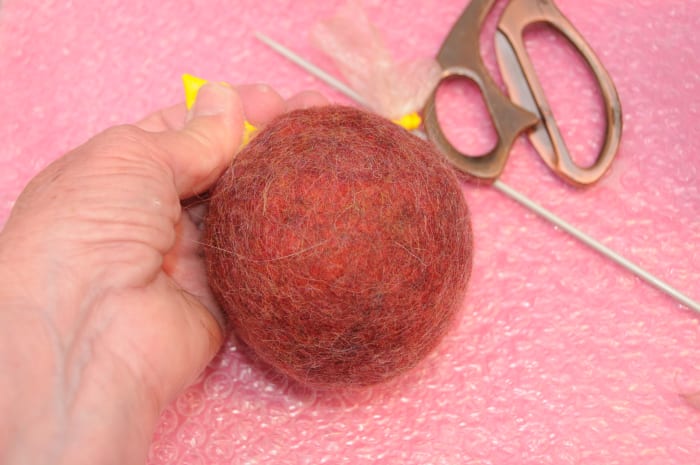 Release some of the water and air, knot the balloon and replace it back in the tumble dryer